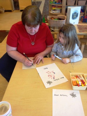 "Here is one of the children working with a teacher on her letter to Arturo. She asked about spelling and punctuation. She wanted to know if Arturo is friends with Amelia and if he is her friend, too."